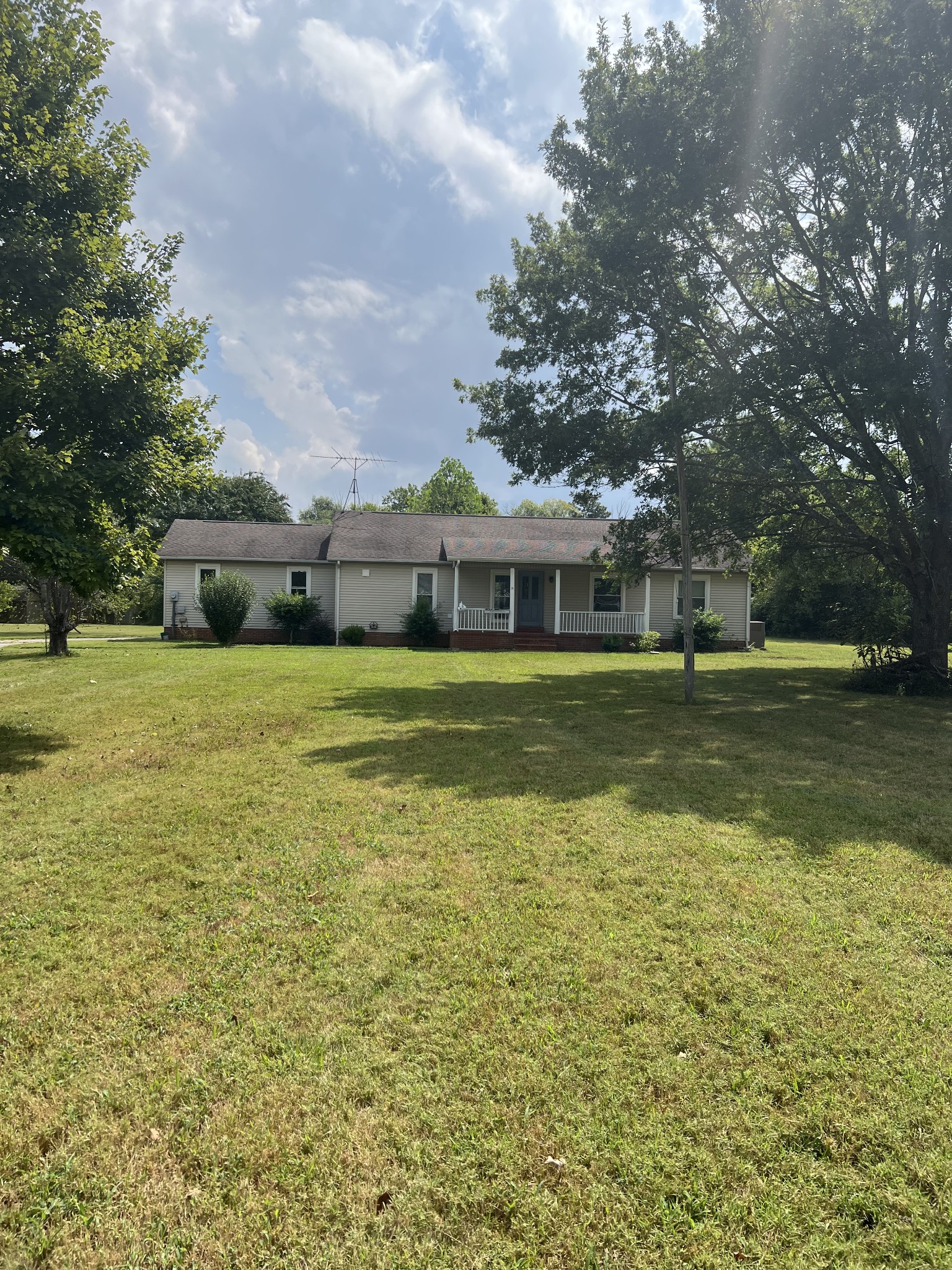 a view of a large pool with a lawn chairs and a big yard