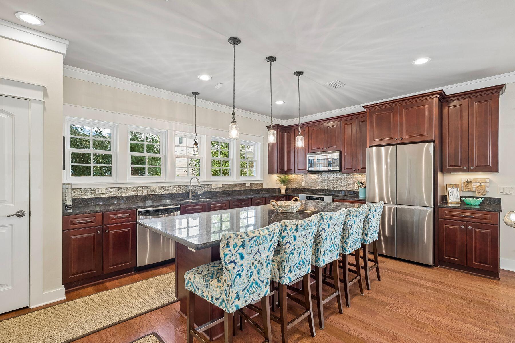 39 Willow Mist Road Inlet Beach, FL 32461 - Photo 10 of 41 a kitchen with stainless steel appliances granite countertop a stove a refrigerator a sink a dining table and chairs with wooden floor