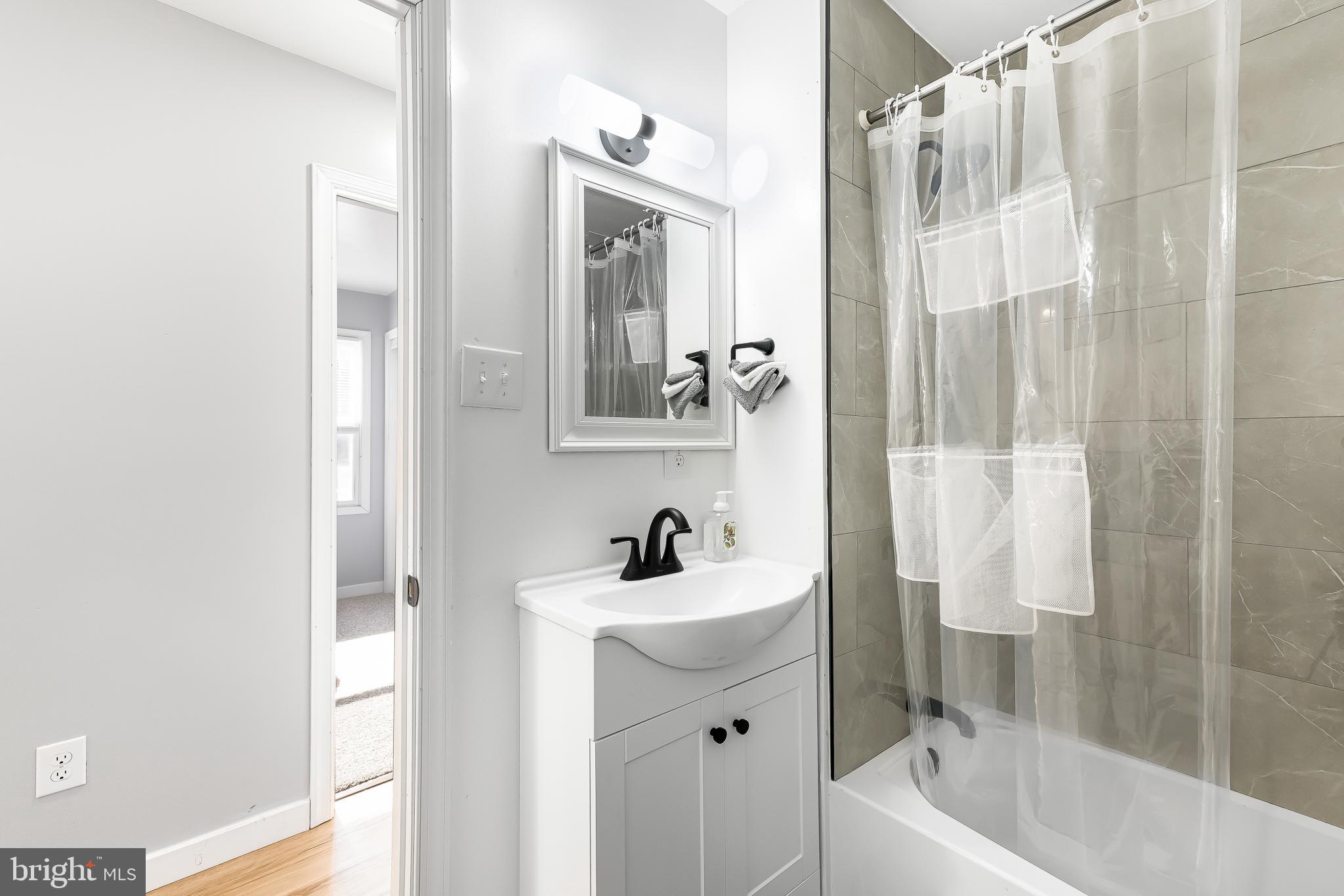 22041 Neal Road Lincoln, DE 19960 - Photo 23 of 28 a bathroom with a sink a mirror a bathtub and shower