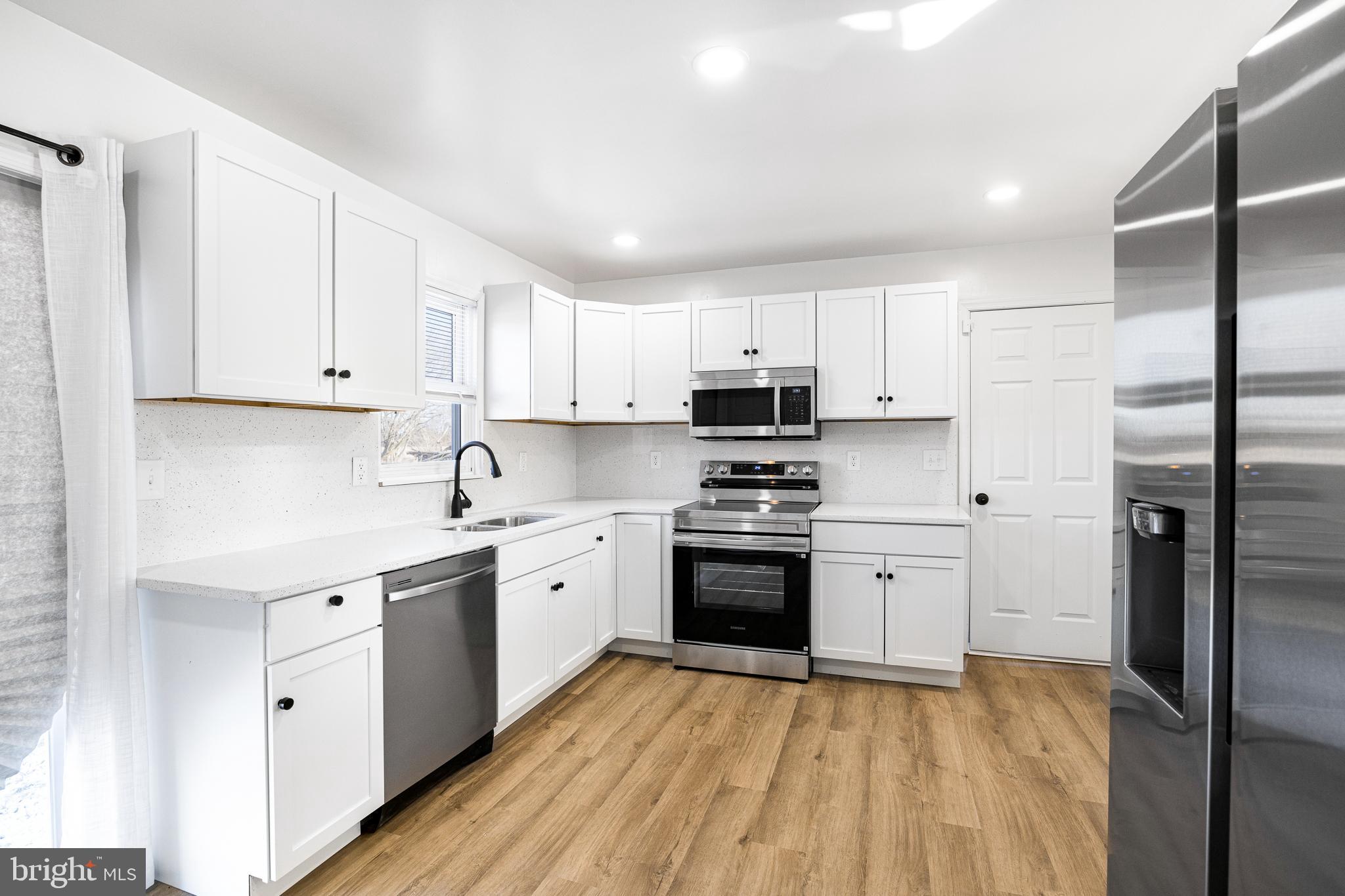 22041 Neal Road Lincoln, DE 19960 - Photo 8 of 28 a kitchen with stainless steel appliances granite countertop a refrigerator sink and white cabinets