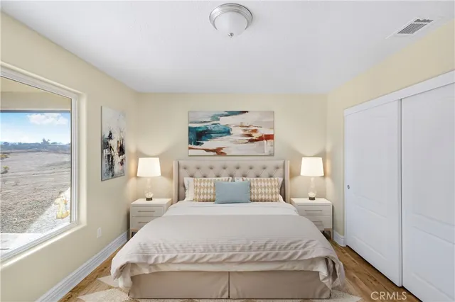 a bedroom with a bed and wooden floor