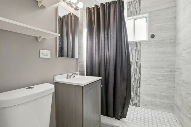 a bathroom with a sink a toilet and shower