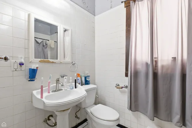 a bathroom with a sink a toilet and shower curtain
