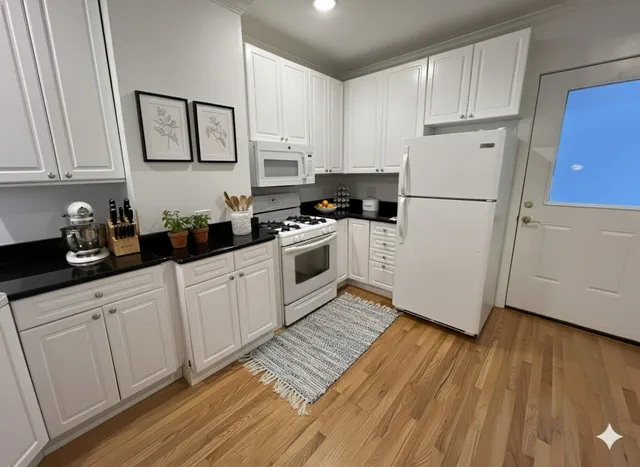 a kitchen with white cabinets and white appliances