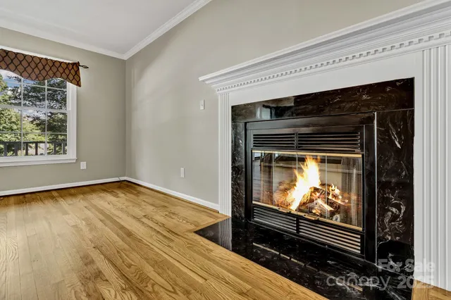 a living room with a fireplace a flat screen tv and a window
