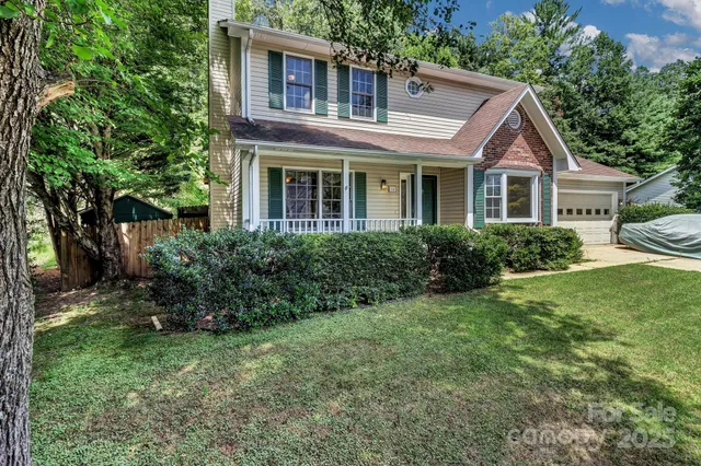 a front view of a house with a yard and trees