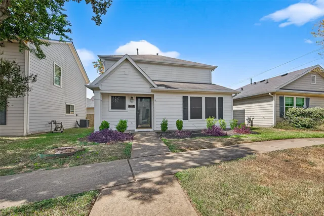 a view of a house with a yard and large tree