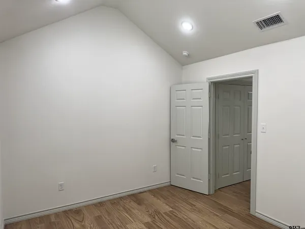 an empty room with wooden floor and closet