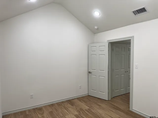 an empty room with wooden floor and closet