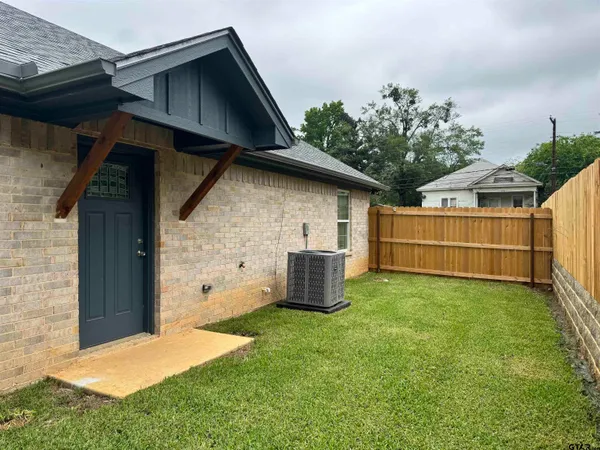 a backyard of a house with table and sofas