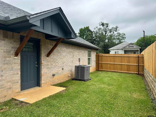 a backyard of a house with table and sofas