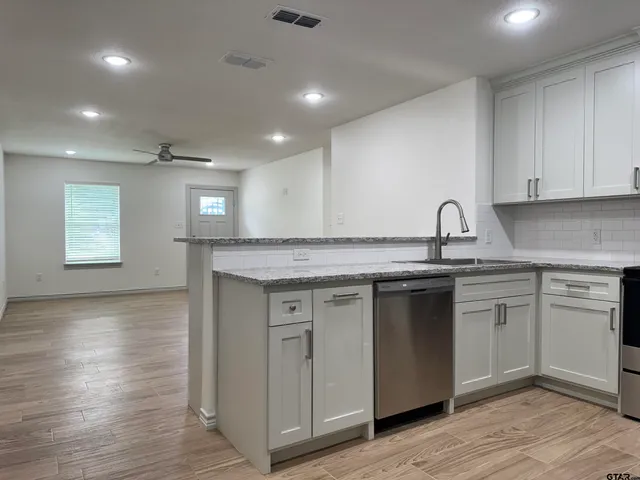 a kitchen with a sink cabinets and wooden floor