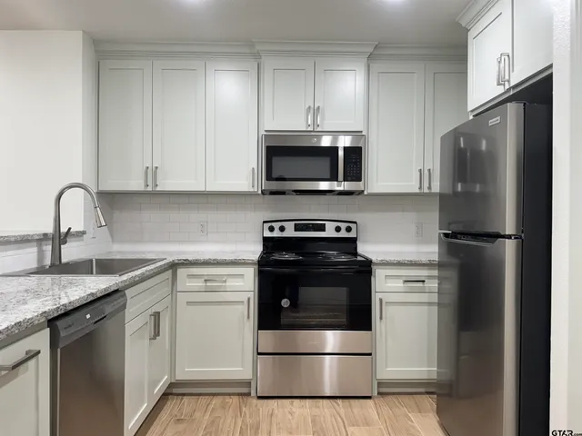a kitchen with cabinets stainless steel appliances and a sink