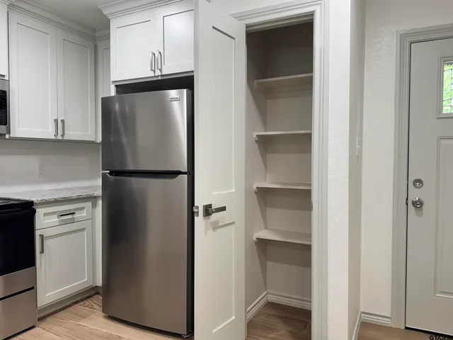 a kitchen with a refrigerator and cabinets