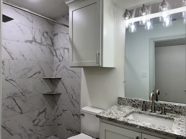a bathroom with a granite countertop sink and a mirror
