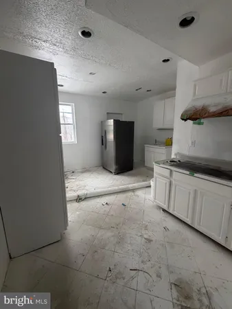 a kitchen with granite countertop a sink and white cabinets