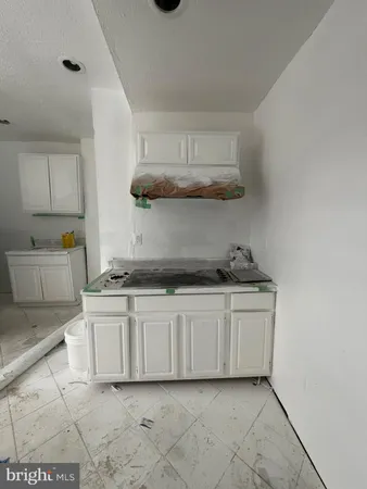 a kitchen with stainless steel appliances granite countertop a sink and white cabinets