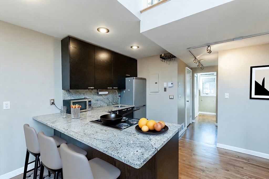 9 Fayette Street, Unit 4 Boston, MA 02116 - Photo 3 of 20 a kitchen with a breakfast area and wooden floor