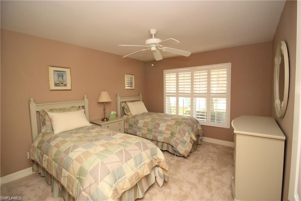 2322 Butterfly Palm Drive Naples, FL 34119 - Photo 13 of 32 a bedroom with two beds and a chandelier