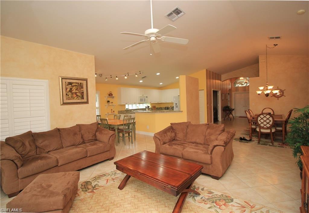 2322 Butterfly Palm Drive Naples, FL 34119 - Photo 16 of 32 a living room with furniture and a large mirror with wooden floor