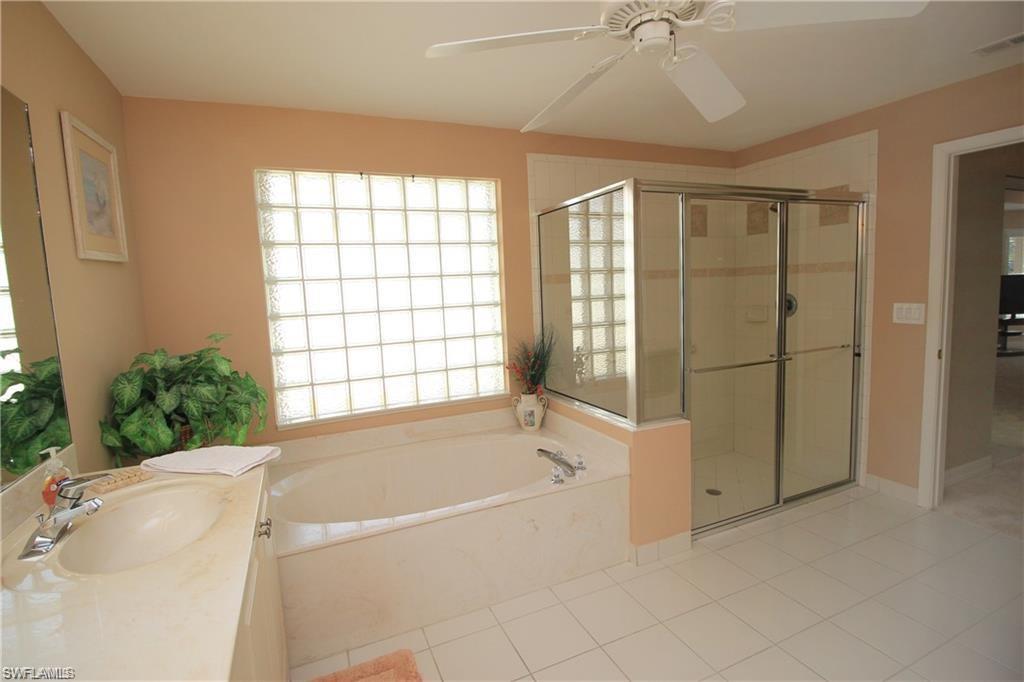 2322 Butterfly Palm Drive Naples, FL 34119 - Photo 17 of 32 a spacious bathroom with a tub shower and window