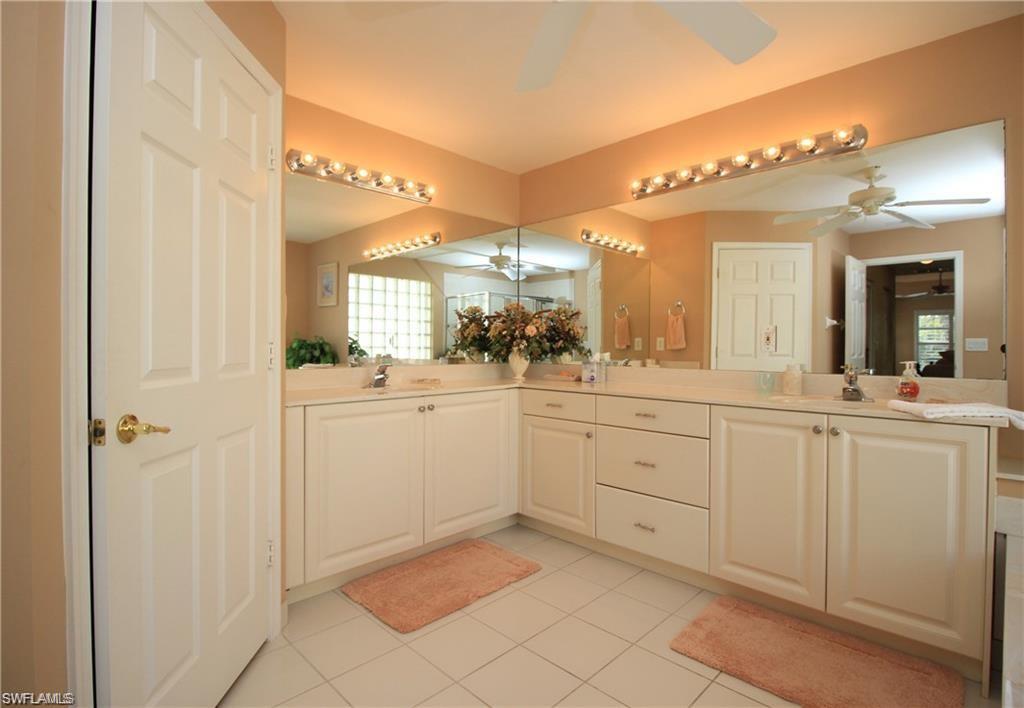 2322 Butterfly Palm Drive Naples, FL 34119 - Photo 18 of 32 a bathroom with a sink a mirror and a vanity