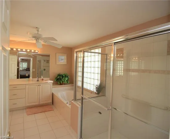 a large bathroom with a large mirror vanity and bathtub