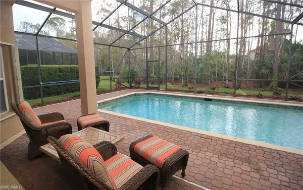 a view of a chairs and table in patio with a lake view