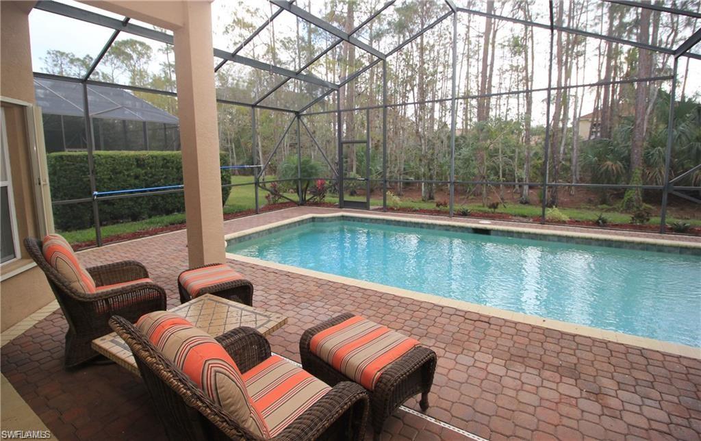 2322 Butterfly Palm Drive Naples, FL 34119 - Photo 20 of 32 a view of a chairs and table in patio with a lake view