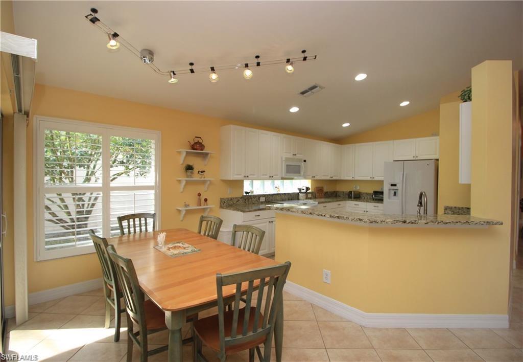 2322 Butterfly Palm Drive Naples, FL 34119 - Photo 3 of 32 a kitchen with stainless steel appliances kitchen island granite countertop a sink and cabinets