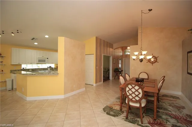 a view of a dining room and kitchen with furniture wooden floor and a chandelier