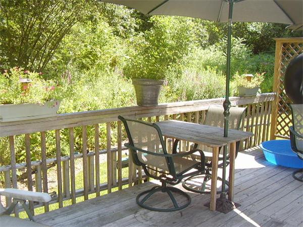 216 Brookfield Road Sturbridge, MA 01518 - Photo 8 of 18 a view of a patio with table and chairs potted plants with wooden floor and fence