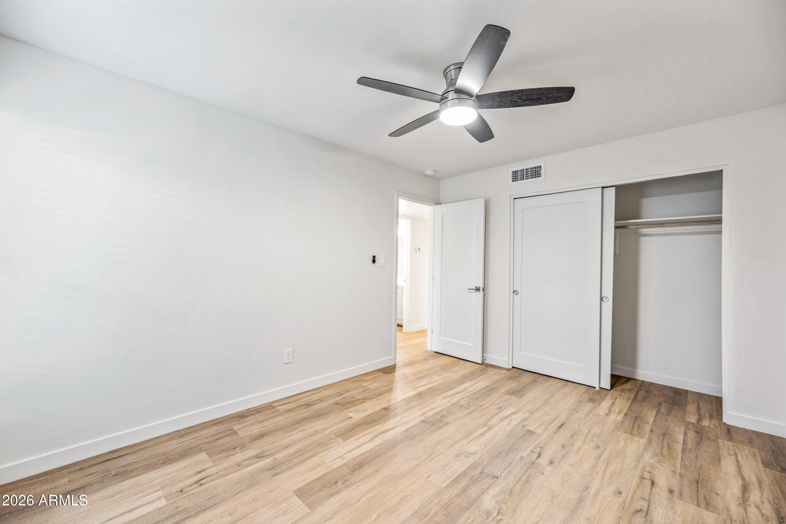 4139 North 27th Street, Unit 1 Phoenix, AZ 85016 - Photo 17 of 31 an empty room with wooden floor fan and windows