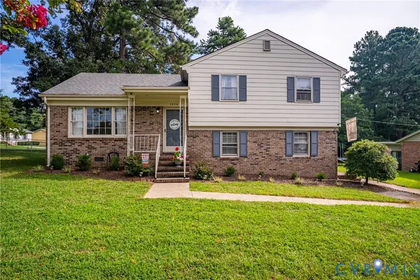 a front view of a house with yard and green space