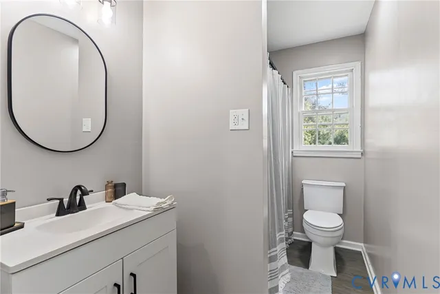 a bathroom with a toilet a sink and mirror