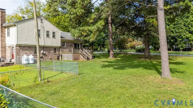 a view of a house with a backyard and a tree