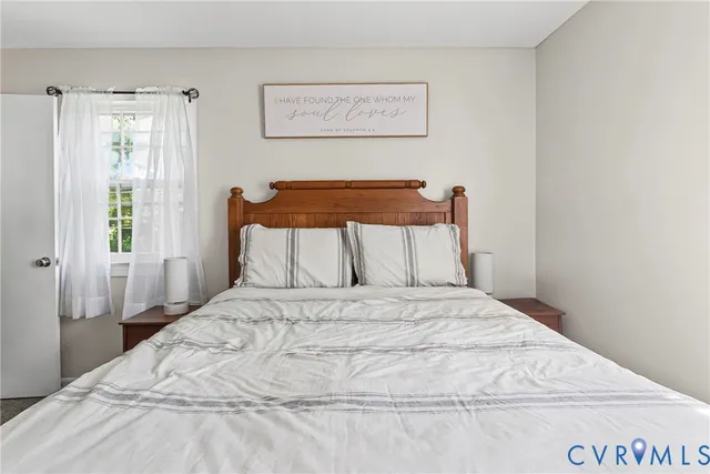 a large bed sitting in a bedroom next to a window