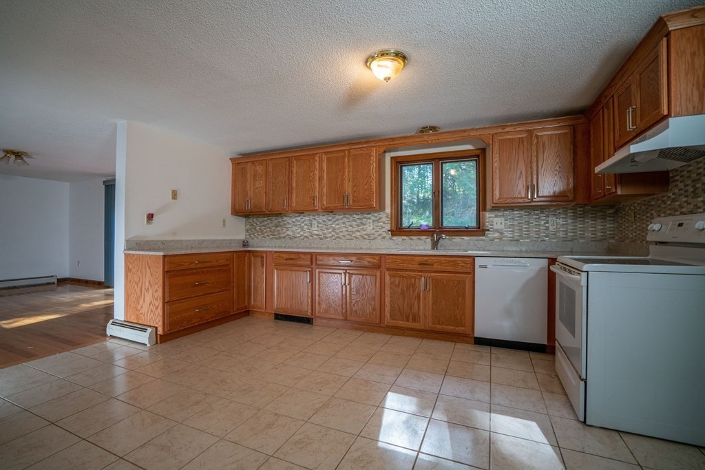 367 Bay Road Amherst, MA 01002 - Photo 5 of 27 a kitchen with granite countertop a stove a sink dishwasher and a refrigerator