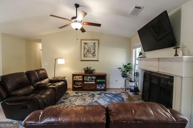 a living room with furniture a flat screen tv and a fireplace