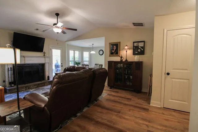 a living room with furniture a fireplace and a flat screen tv
