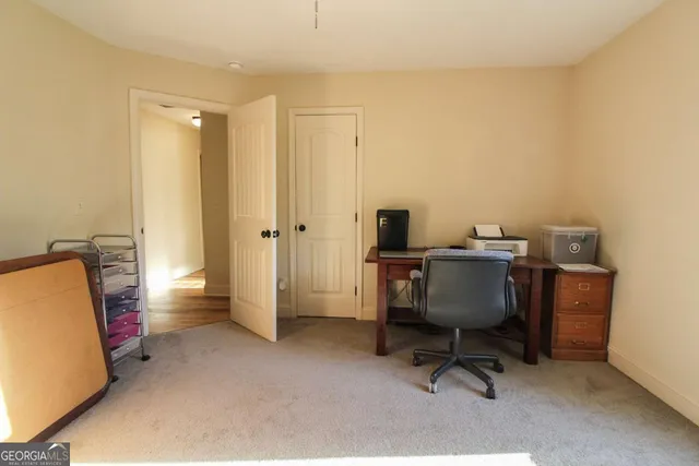 a view of a workspace with furniture and a bathroom