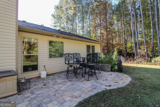 a view of a house with backyard and sitting area