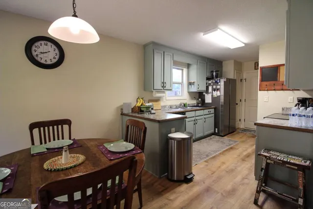 a kitchen with a table chairs a stove and a refrigerator