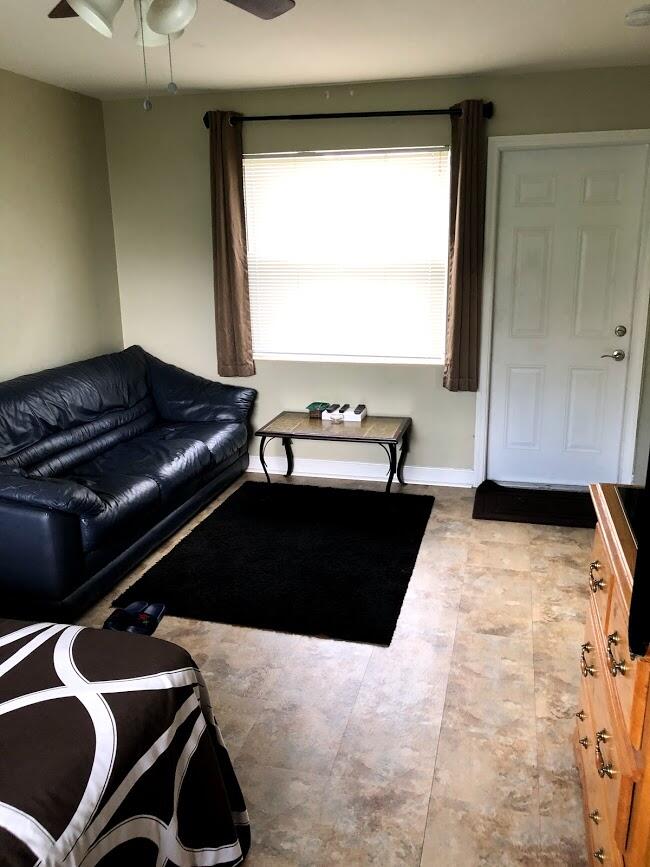26 Wisconsin Street, Unit 2 Palm Springs, FL 33461 - Photo 6 of 6 a living room with a couch and a large window