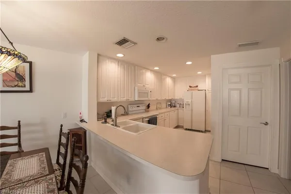 a room with stainless steel appliances furniture and a kitchen view