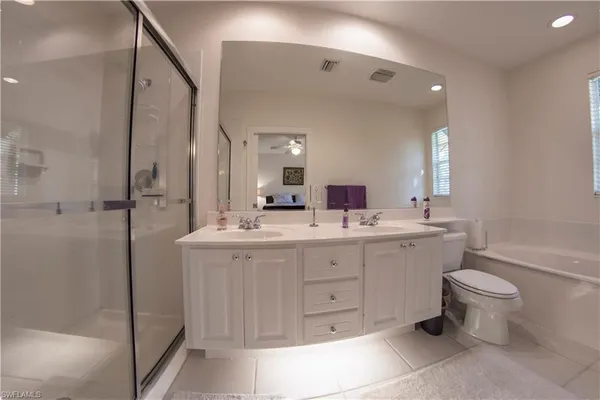 a bathroom with a double vanity sink a toilet and a mirror