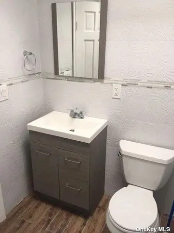 a bathroom with a sink mirror vanity and toilet