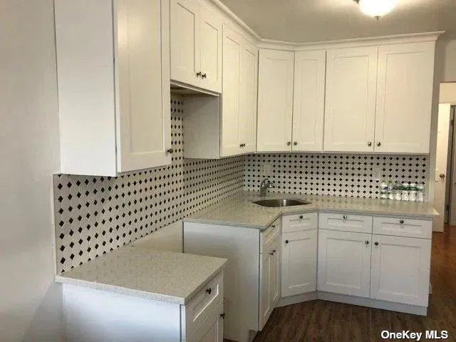 a view of a utility room with granite countertop cabinets