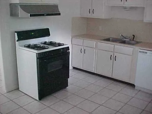 a kitchen with white cabinets and appliances