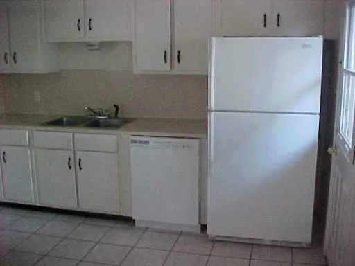a kitchen with cabinets and white stainless steel appliances